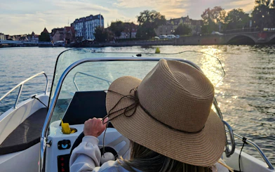 Self-driving an electric boat on the Motława River in Gdansk at sunset.