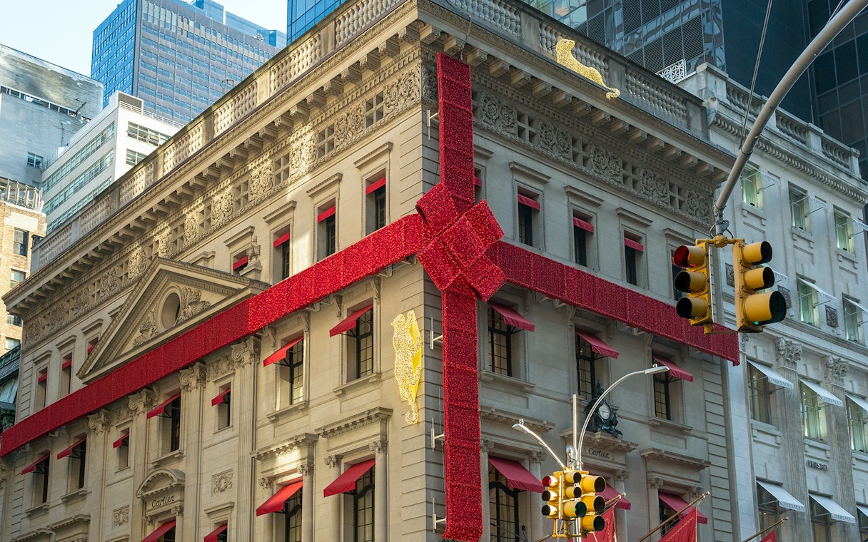 Historic building wrapped in red ribbon for holiday lights tour in New York City.