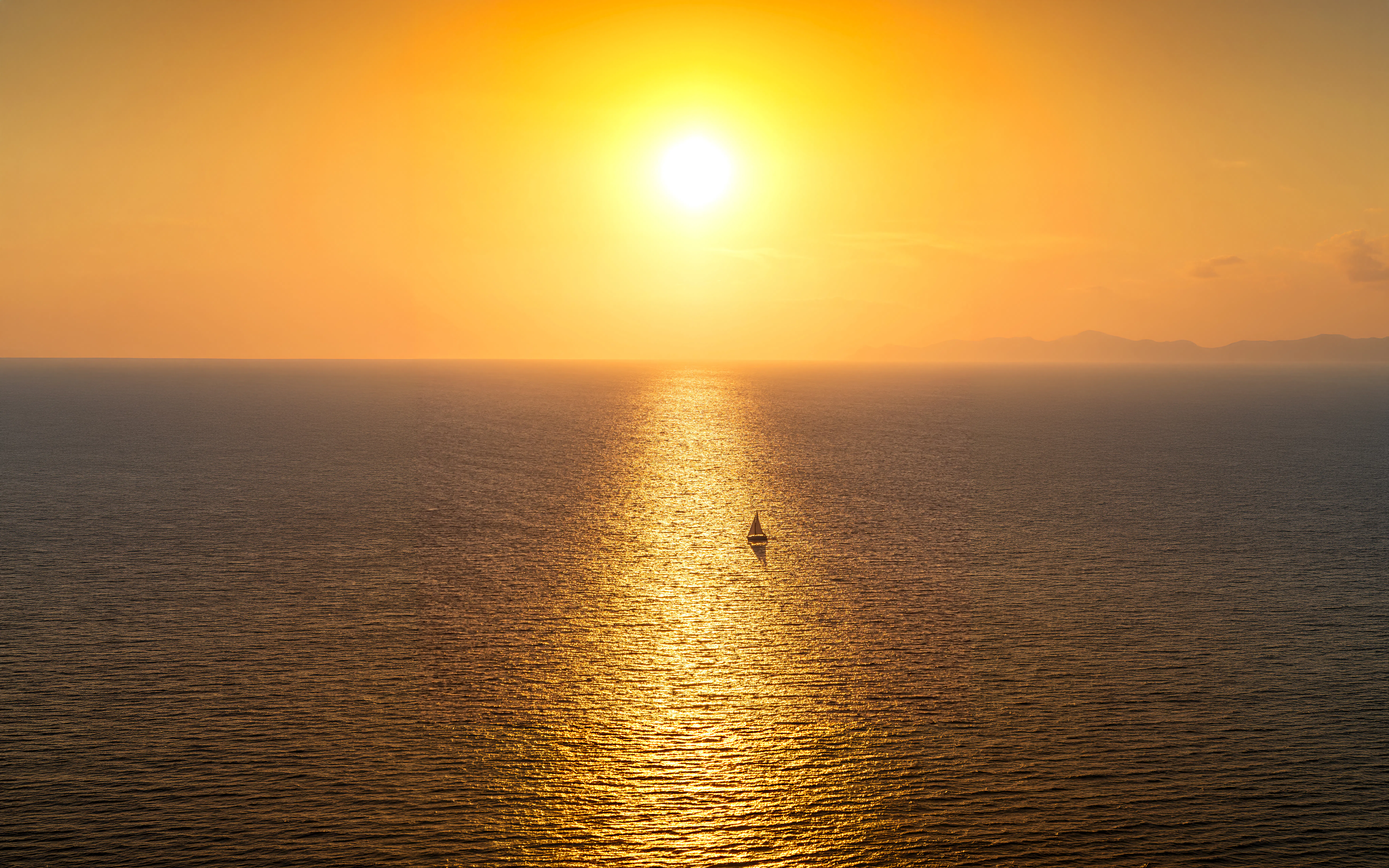 Sailboat on the Aegean Sea during a Santorini sunset.