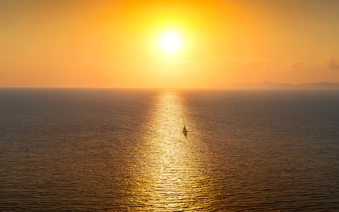 Sailboat on the Aegean Sea during a Santorini sunset.