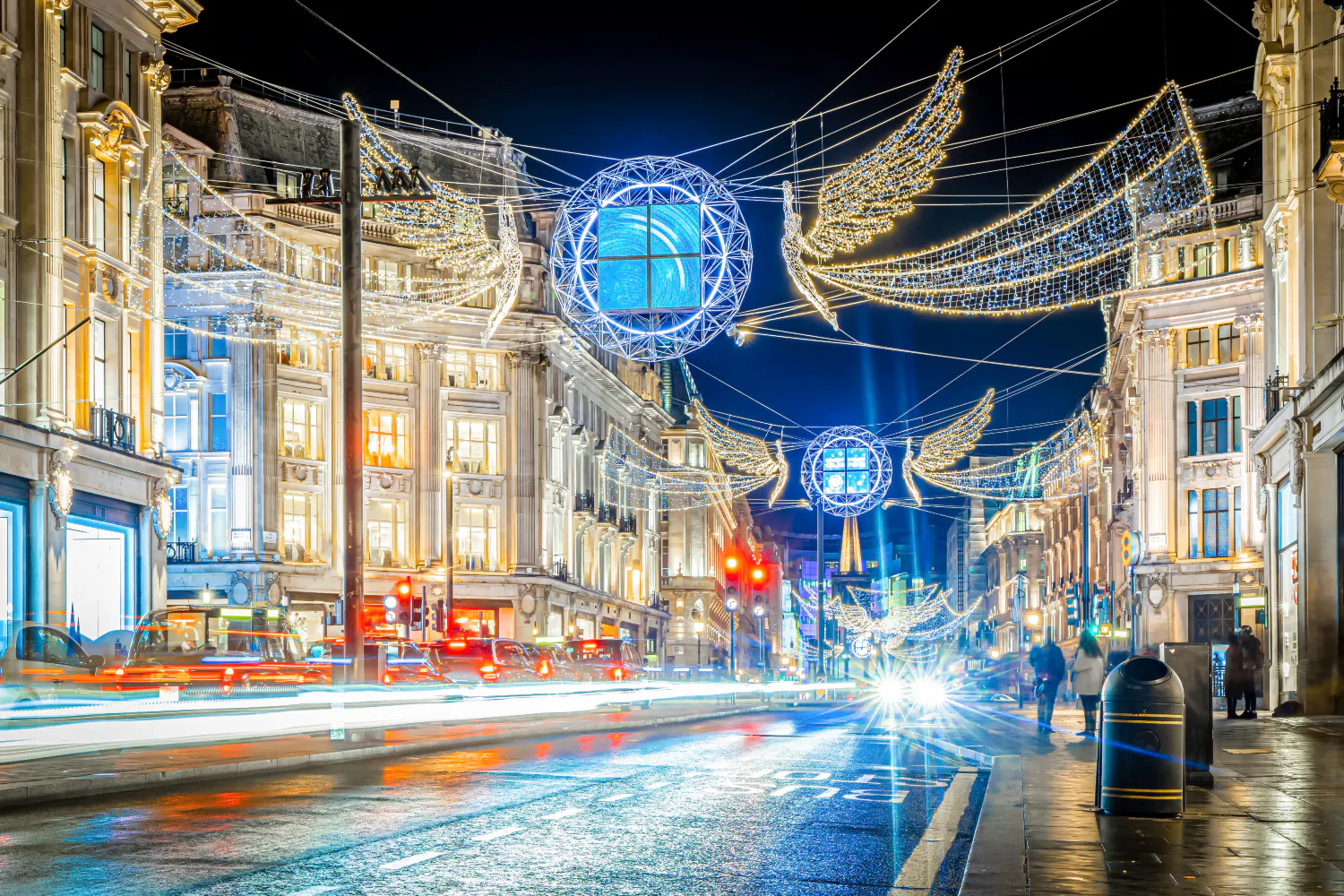 London street adorned with Christmas lights and decorations during Santa's Magical Express bus tour.