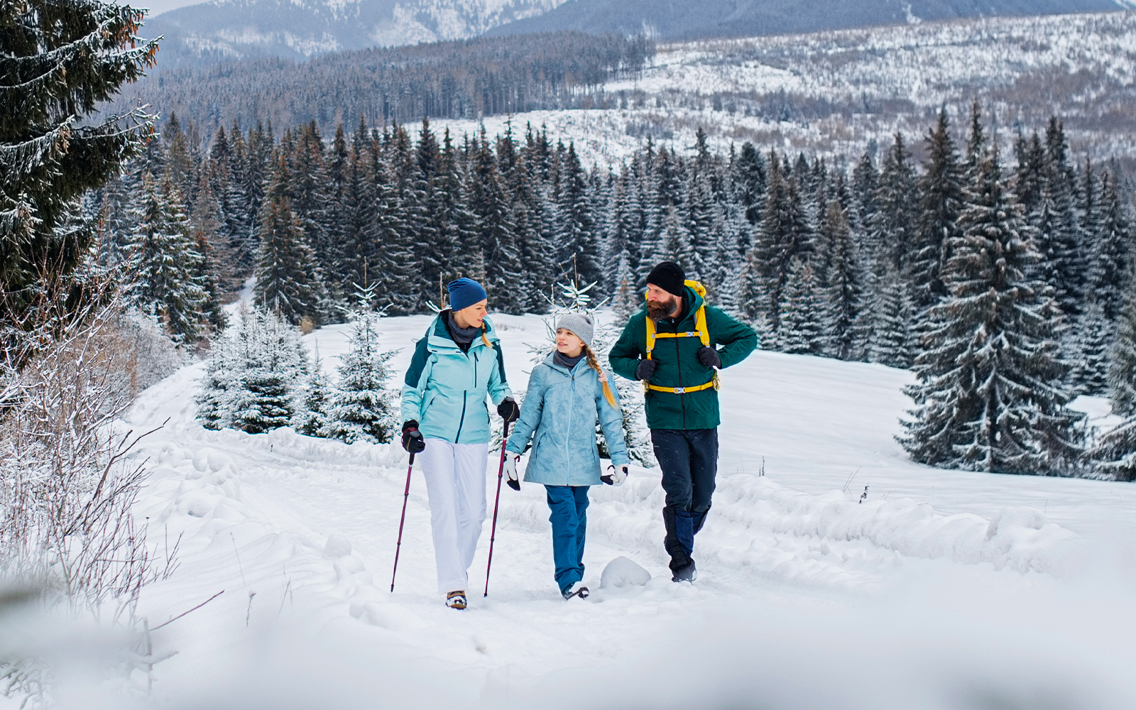 family winter walking in snowy mountain area