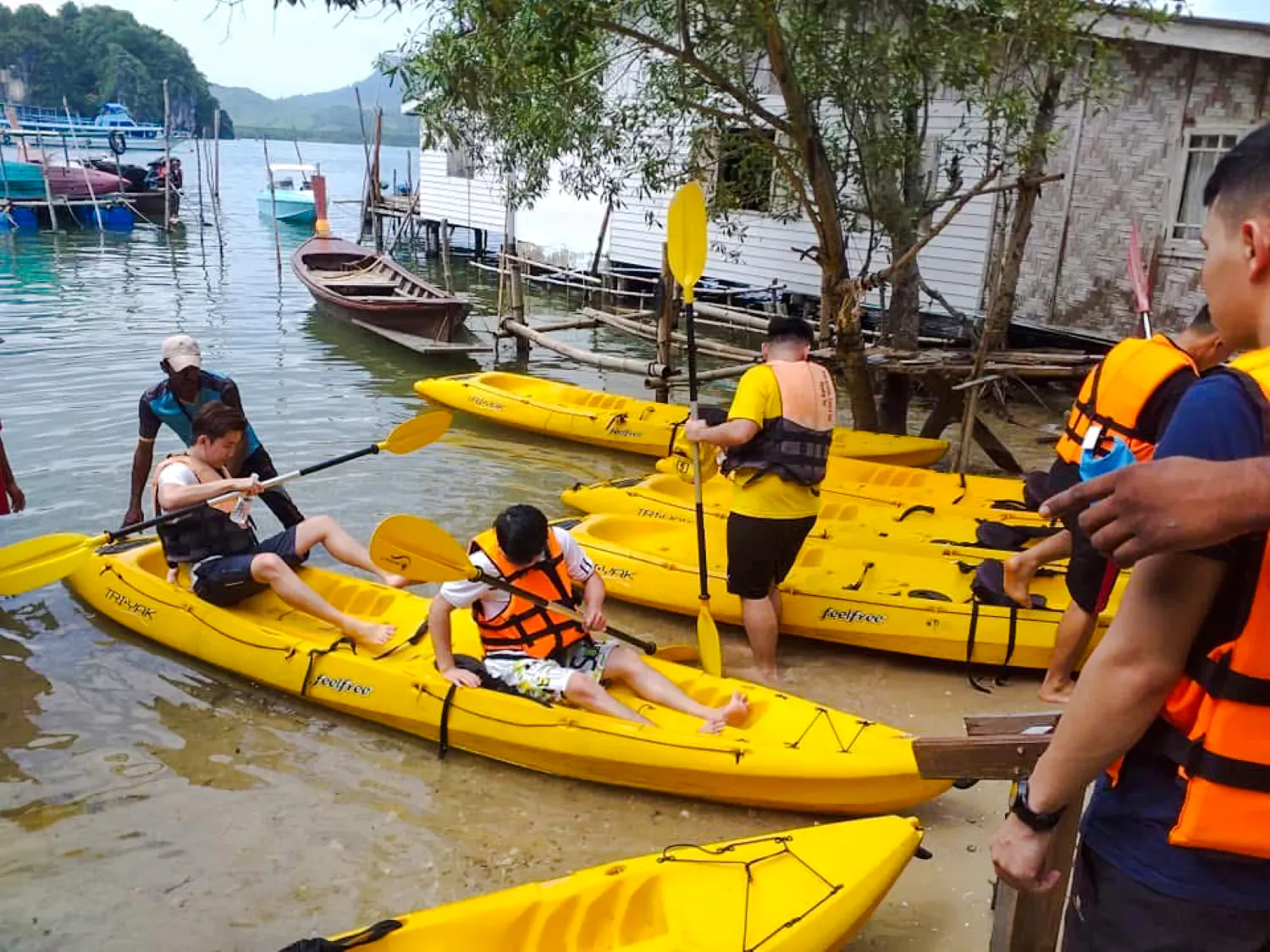 Kayakers preparing to launch at Ao Thalane, Krabi, with yellow kayaks and life vests.