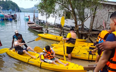 Kayakers preparing to launch at Ao Thalane, Krabi, with yellow kayaks and life vests.