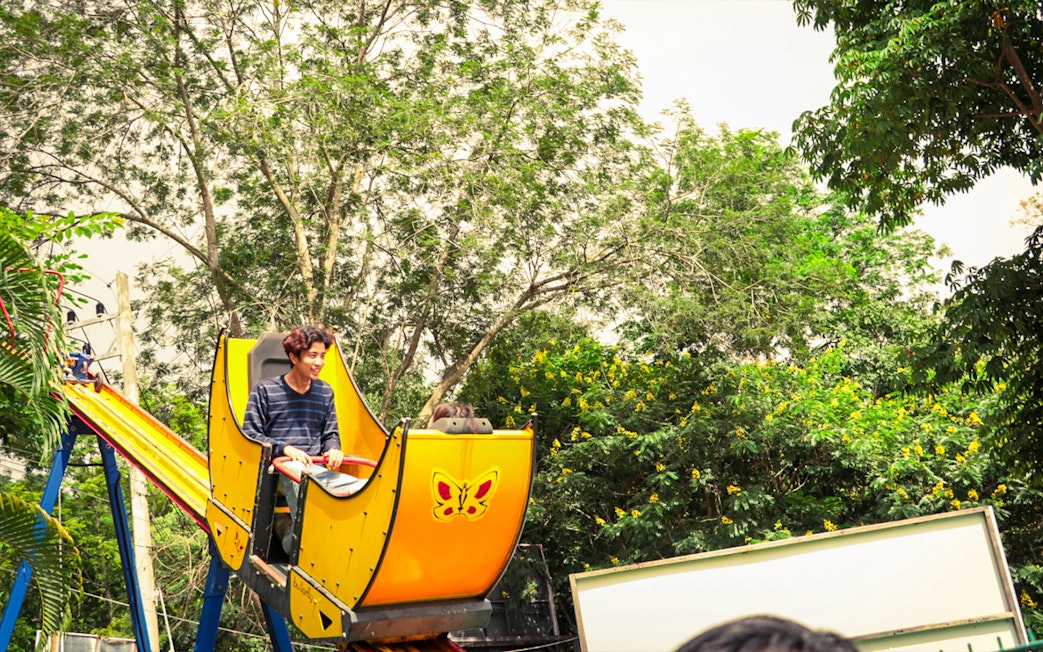 Man on a yellow cart at the top of a slide in Pongyang Adventure Park, Chiang Mai.