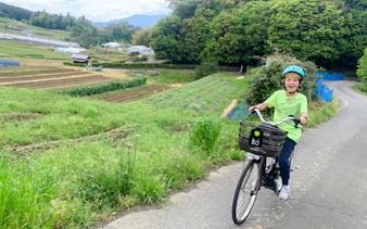 Cyclist on e-bike tour through rural landscape in Asuka, Nara, with English-speaking guide.