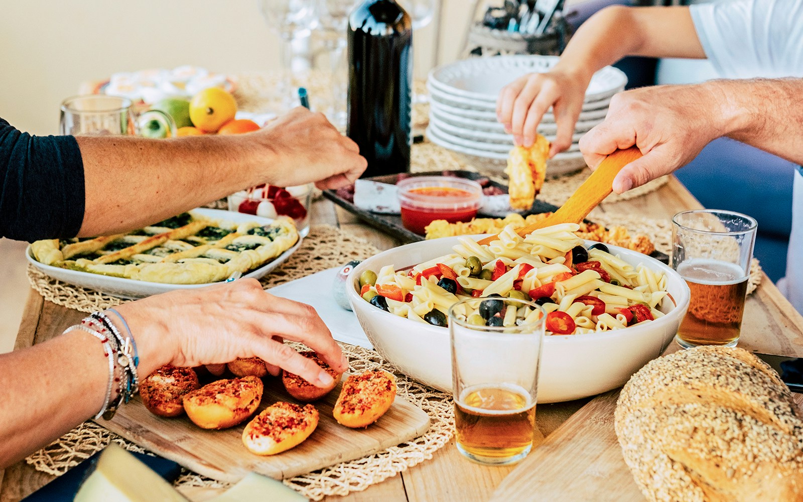 Assorted Italian pastas and breads displayed on a rustic wooden table.