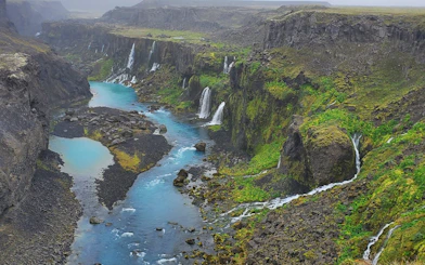 Waterfalls cascading into a turquoise river in Landmannalaugar Highlands, Iceland.