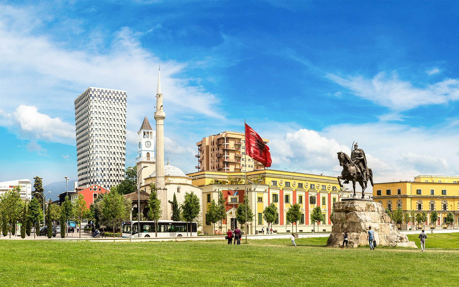 Skanderbeg Square in Tirana with statue, mosque, and modern buildings.