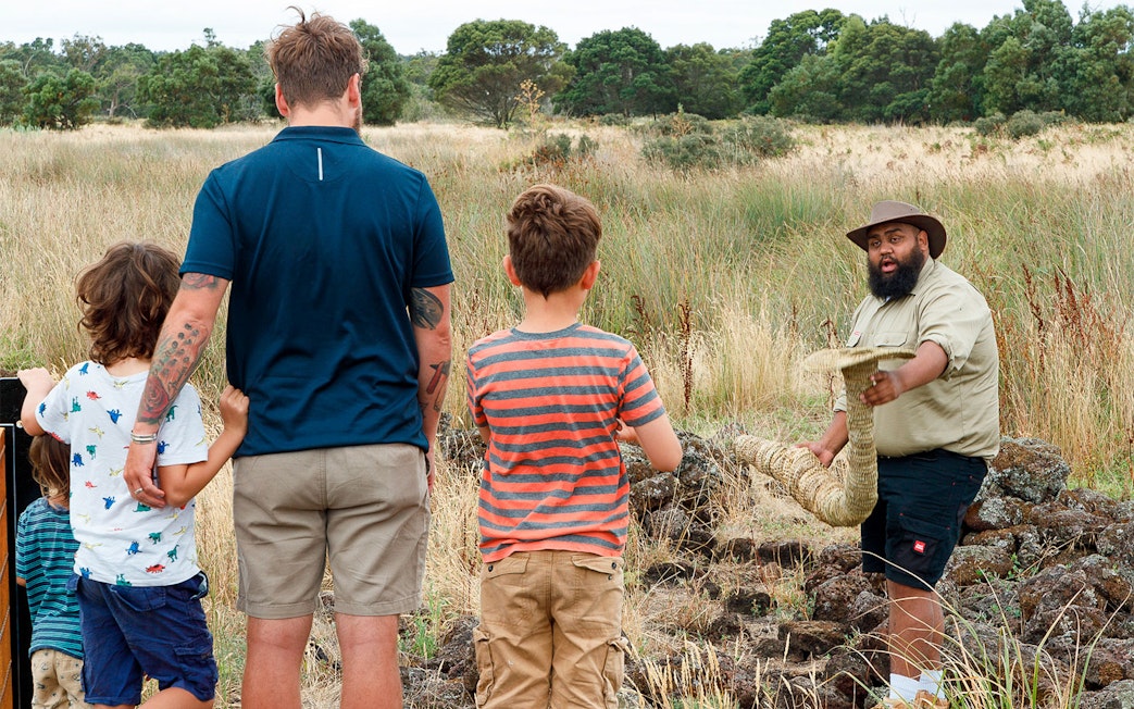 Guide demonstrating traditional tool to group on Kooyang Yana Walk.