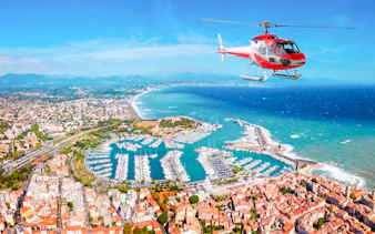 Helicopter flying over Nice coastline and marina during panoramic tour.