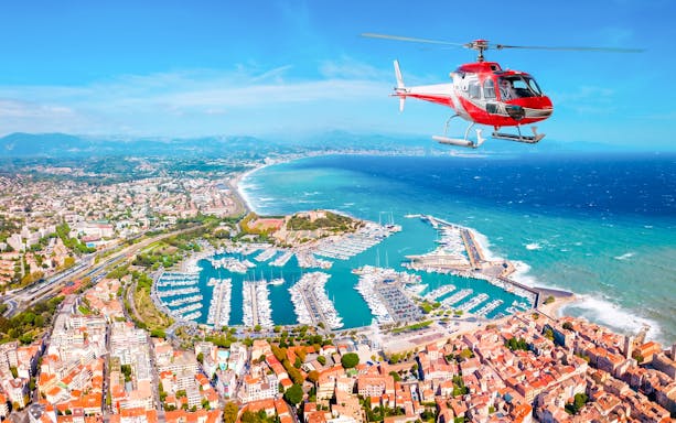 Helicopter flying over Nice coastline and marina during panoramic tour.