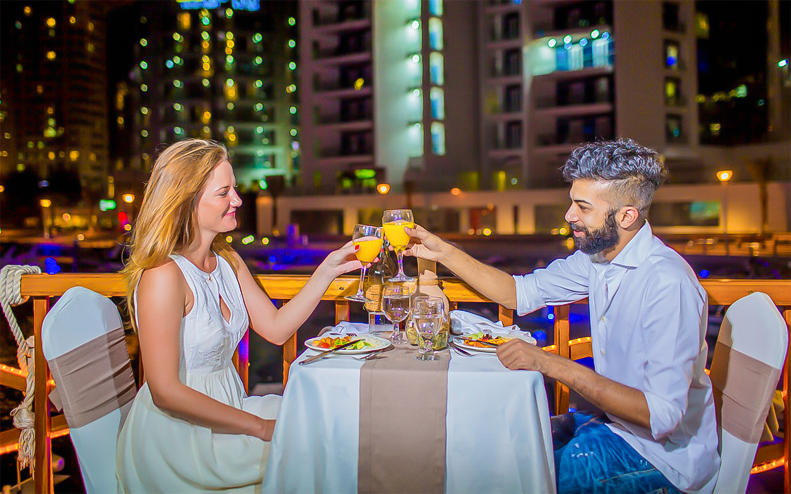 Couple enjoying a cocktails with neon lit streets in Nashville.
