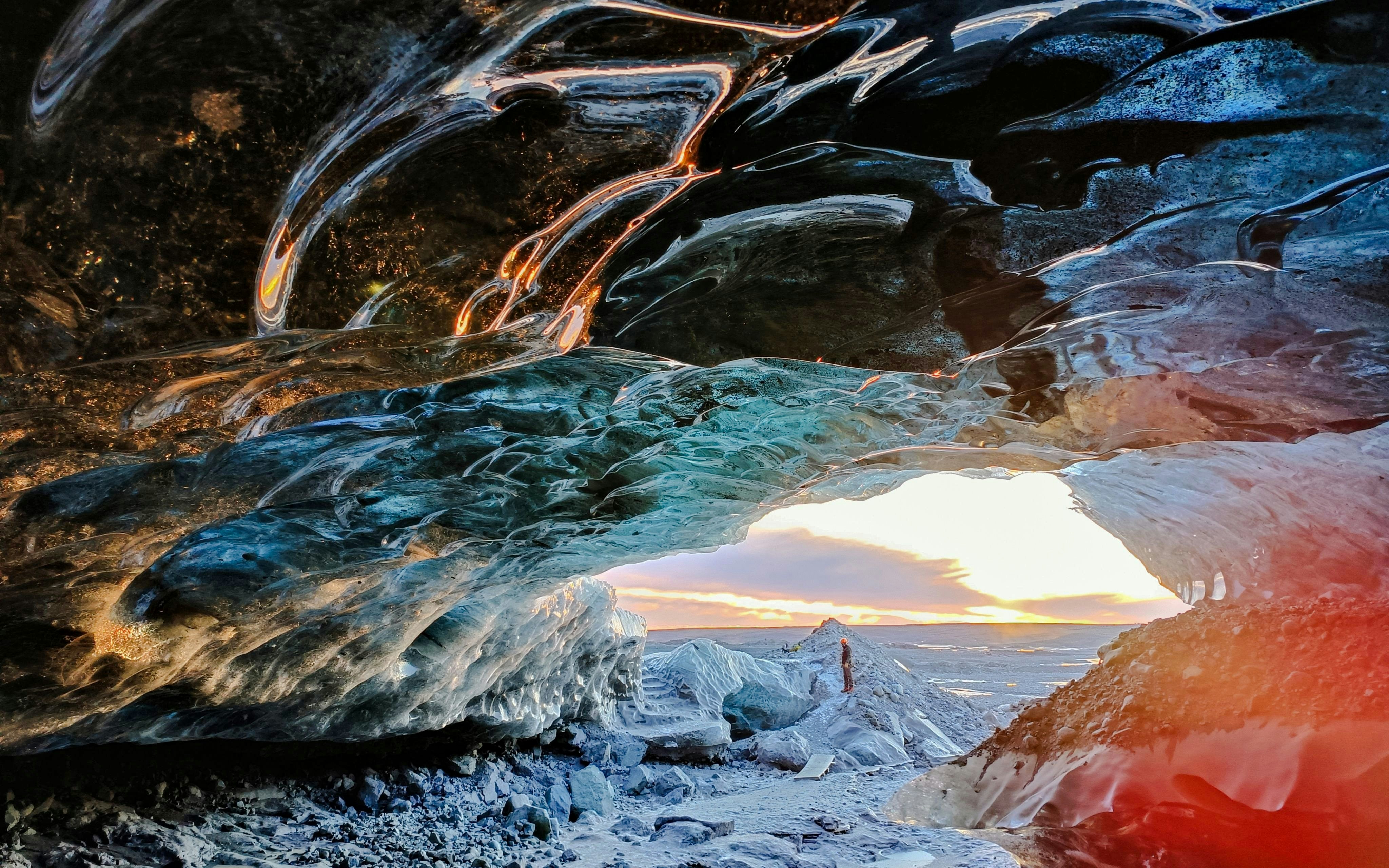 Ice cave interior with sunset view at Katla volcano, Iceland.