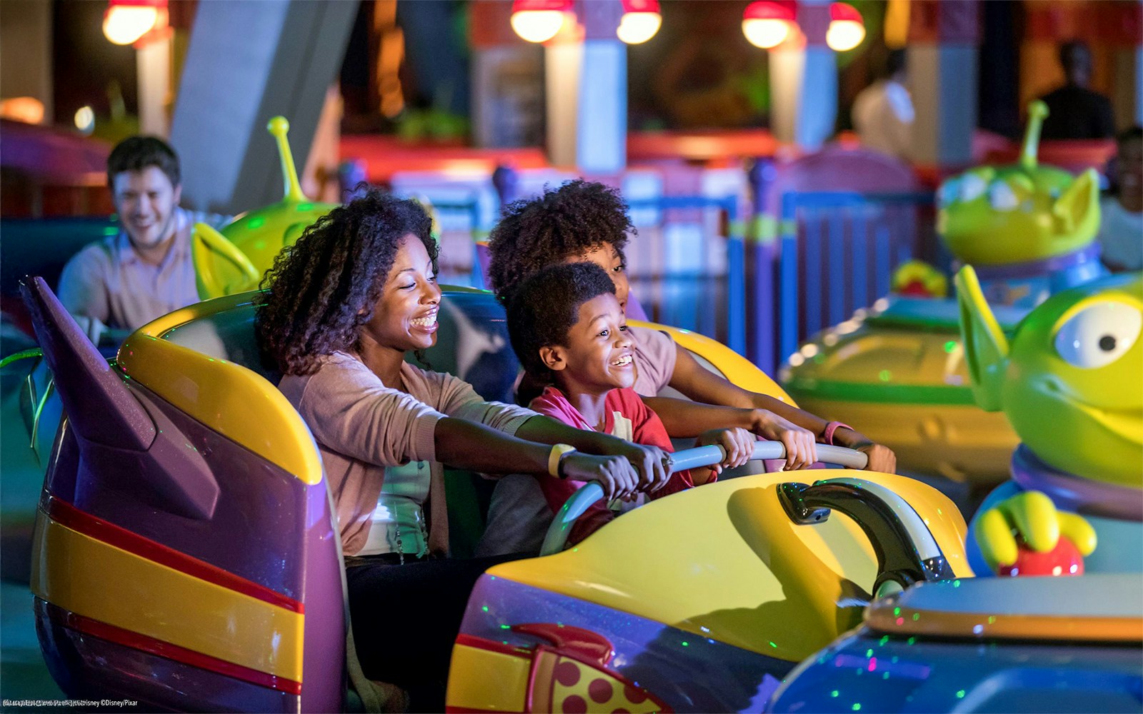 Family enjoying bumper cars at Toy Story attraction, Walt Disney World Resort, Orlando.