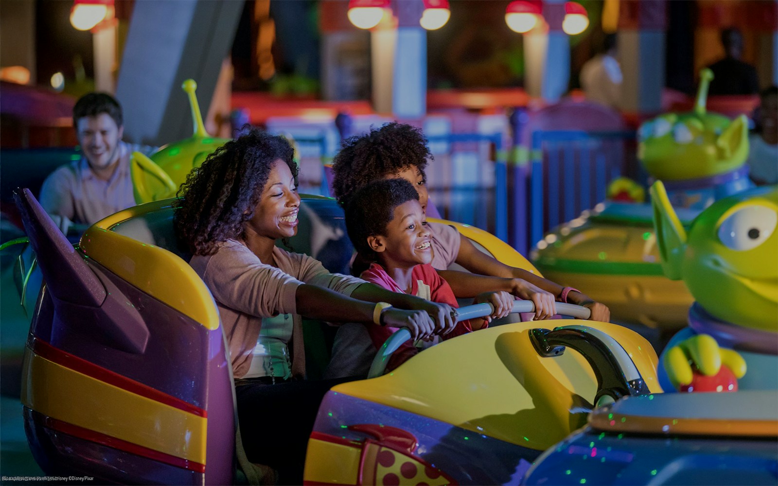Family enjoying bumper cars at Toy Story attraction, Walt Disney World Resort, Orlando.