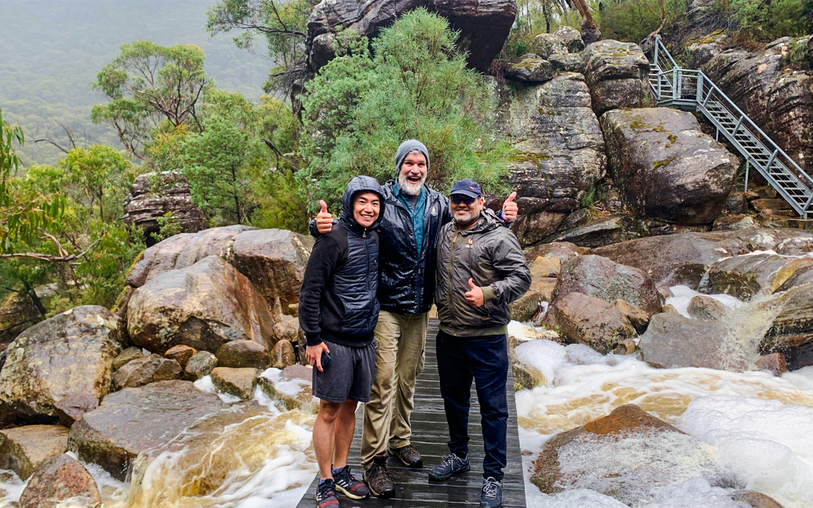 Guide and guests on a rocky trail in a lush forest setting.