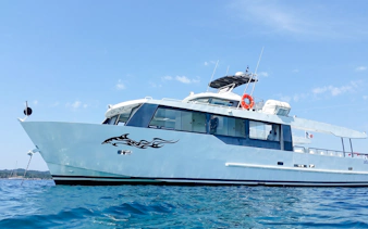 Tour boat cruising on clear waters during Monaco boat tour.