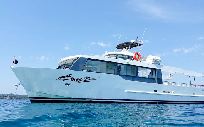 Tour boat cruising on clear waters during Monaco boat tour.