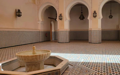Fountain in a tiled courtyard at Meknes, Morocco, showcasing intricate Moroccan architecture.