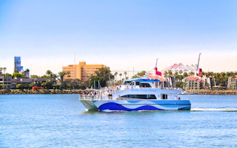 Whale watching boat on Los Angeles harbor with city skyline in background.
