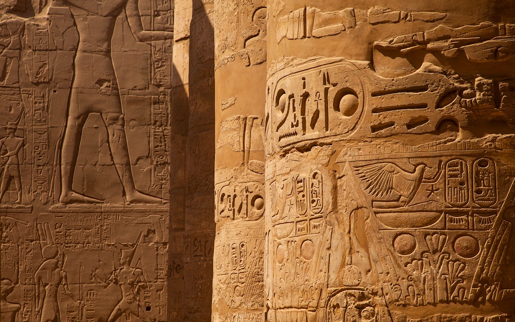 Intricate hieroglyphs on temple columns in Egypt.
