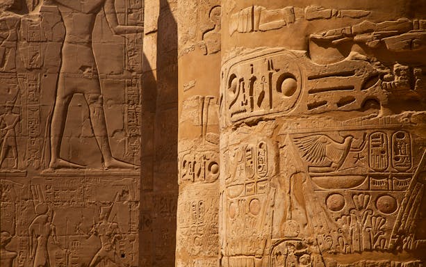 Intricate hieroglyphs on temple columns in Egypt.