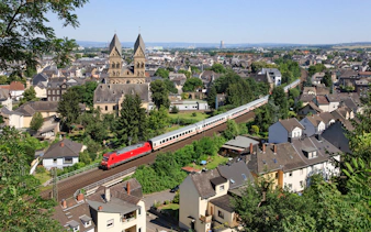 Euro Rail train passing through a German town with historic church in view.