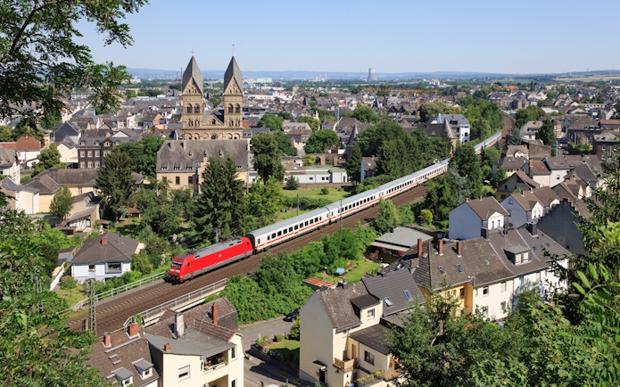 Euro Rail train passing through a German town with historic church in view.