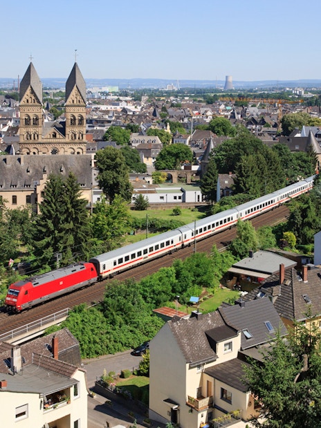 Euro Rail train passing through a German town with historic church in view.