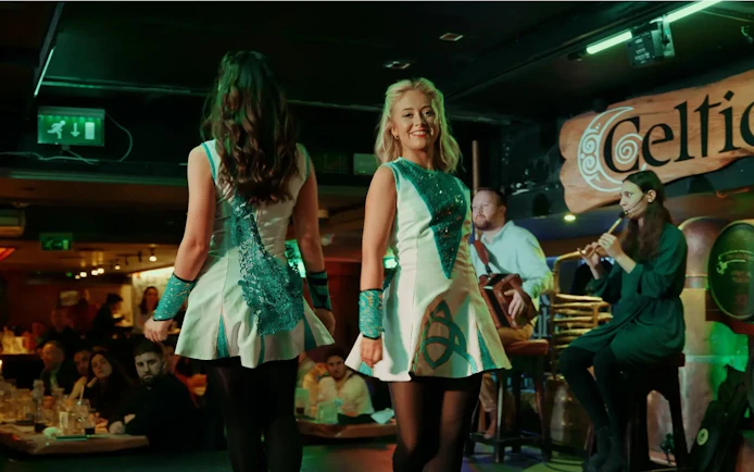 Irish dancers performing at Celtic Nights show in Dublin with live musicians.