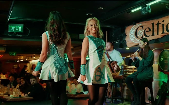 Irish dancers performing at Celtic Nights show in Dublin with live musicians.