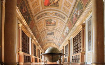 Château de Fontainebleau interior with ornate ceiling and large globe.