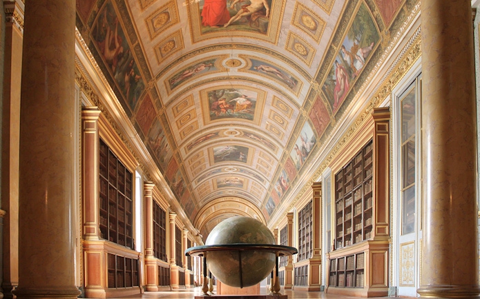 Château de Fontainebleau interior with ornate ceiling and large globe.