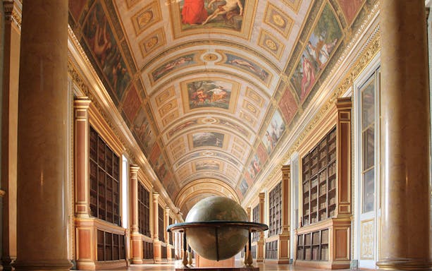 Château de Fontainebleau interior with ornate ceiling and large globe.