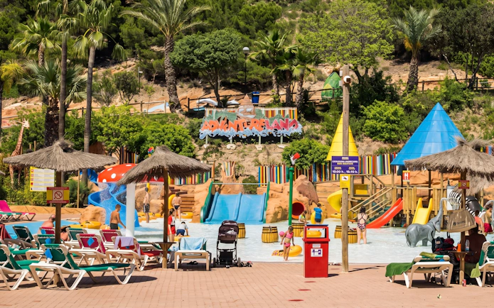 Adventureland water play area at Aqualandia Benidorm, Spain with slides and palm trees.