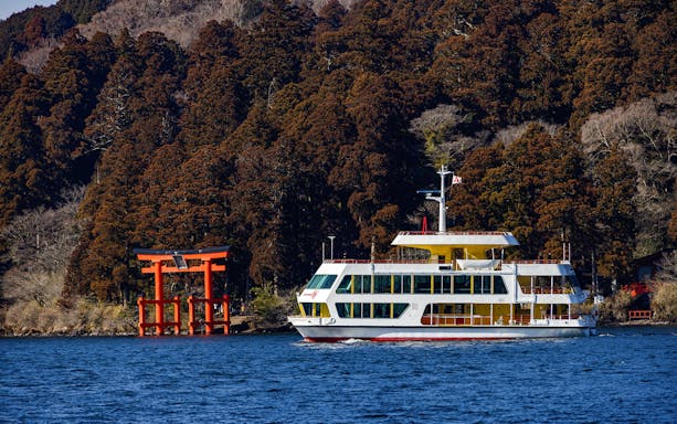 Mt Fuji reflected in Lake Ashi, Hakone, with a traditional boat sailing in the foreground.