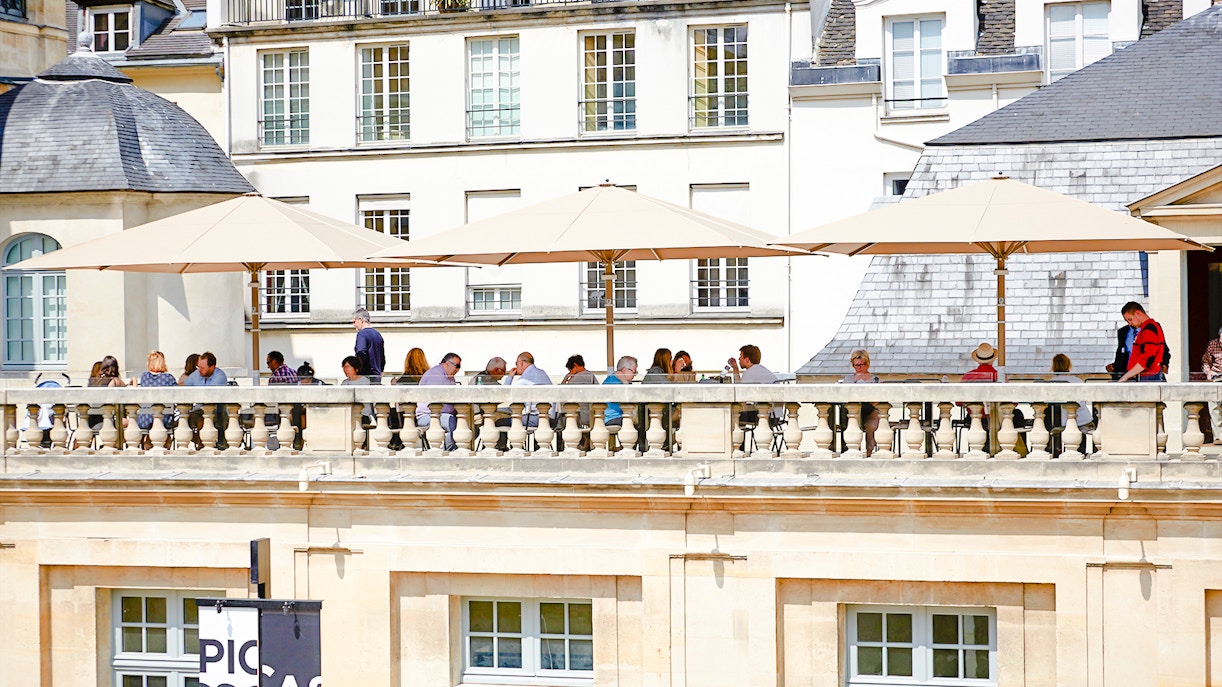 Picasso Museum terrace cafe in Paris with visitors enjoying outdoor seating.