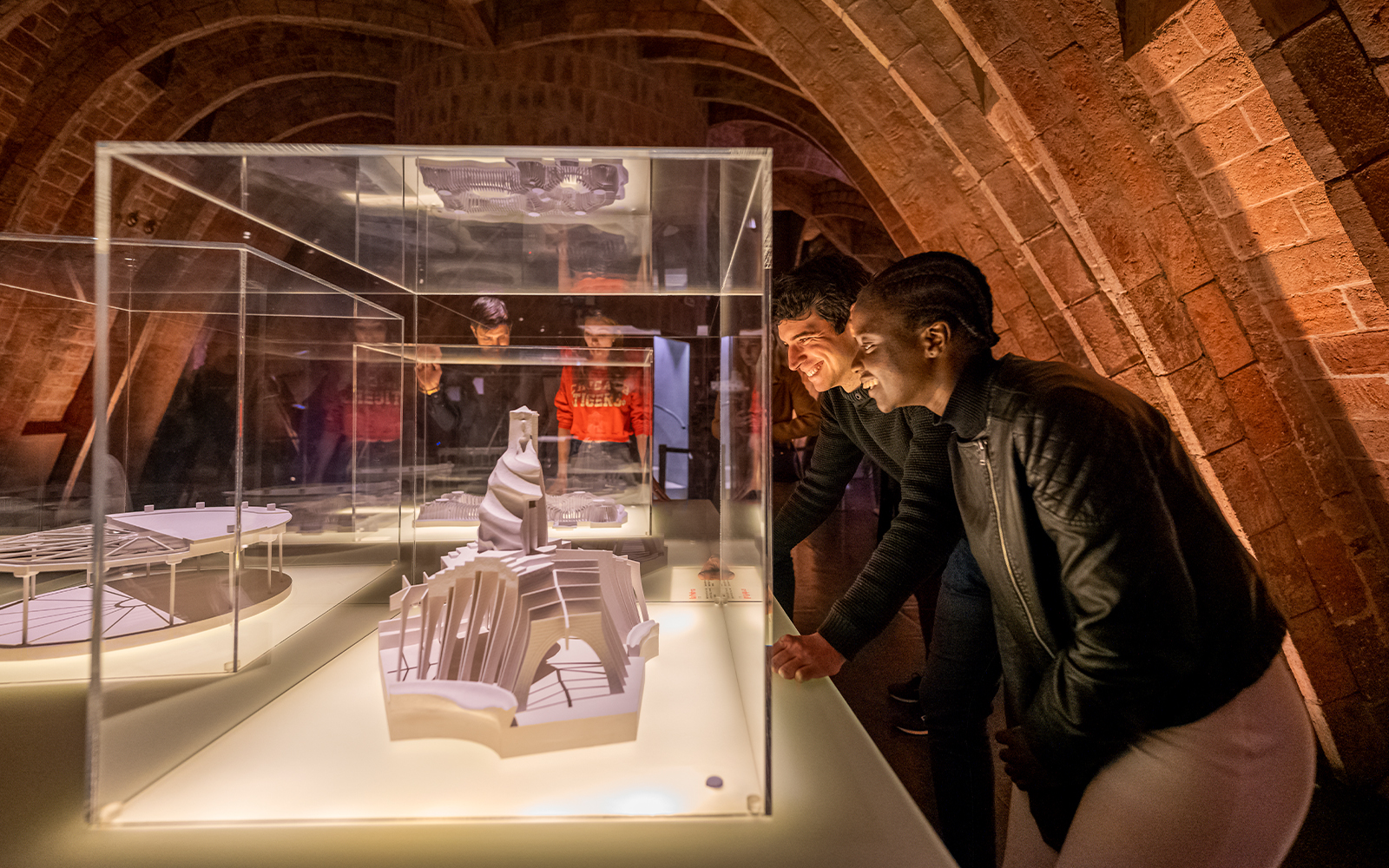 Guests observing architectural models at La Pedrera Casa Mila night tour in Barcelona.