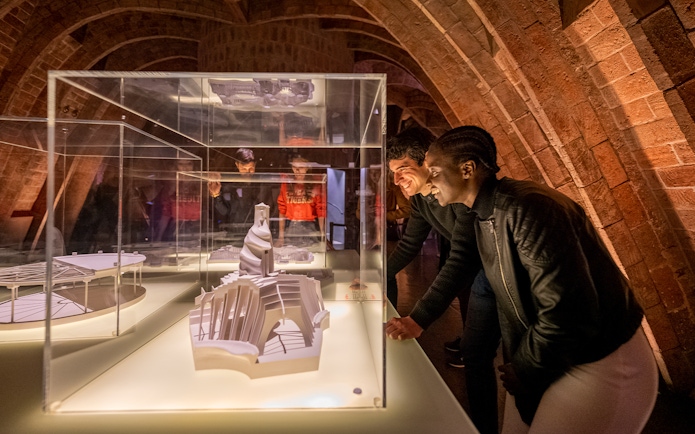 Guests observing architectural models at La Pedrera Casa Mila night tour in Barcelona.