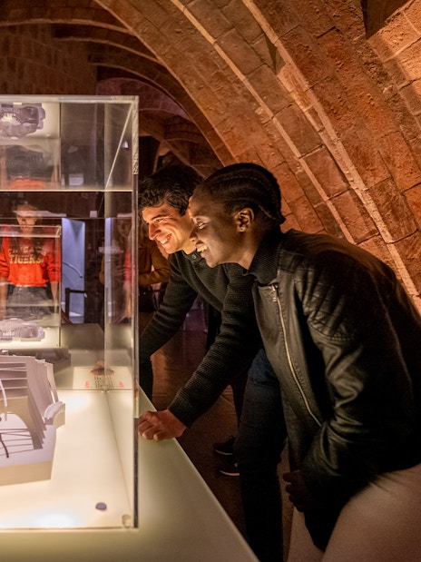 Guests observing architectural models at La Pedrera Casa Mila night tour in Barcelona.