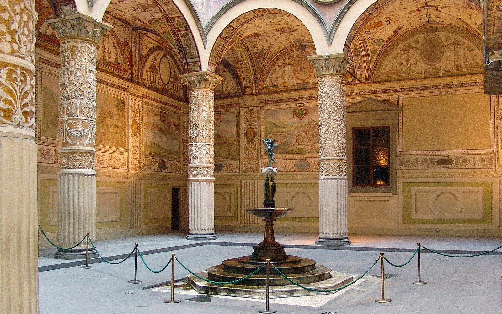 Palazzo Vecchio courtyard with ornate columns and central fountain in Florence, Italy.