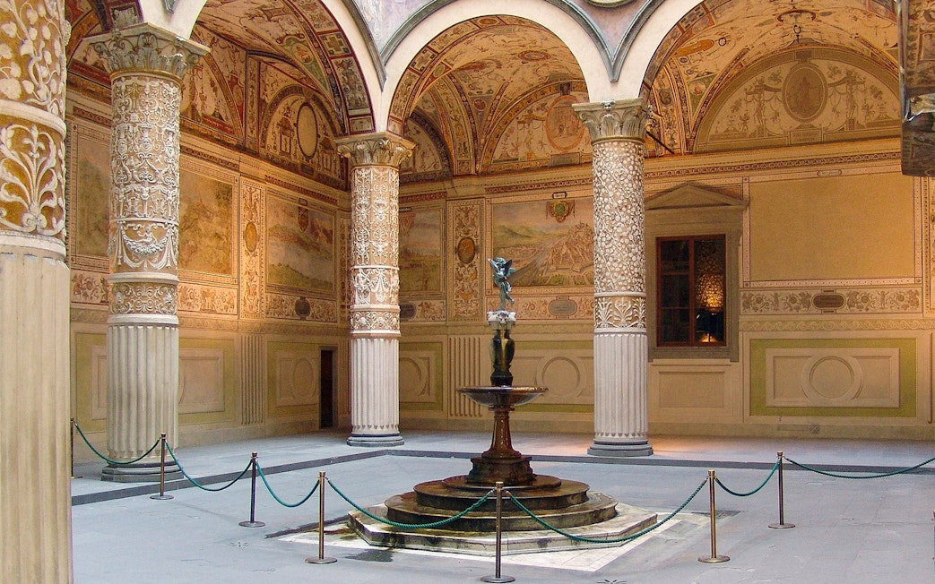 Palazzo Vecchio courtyard with ornate columns and central fountain in Florence, Italy.