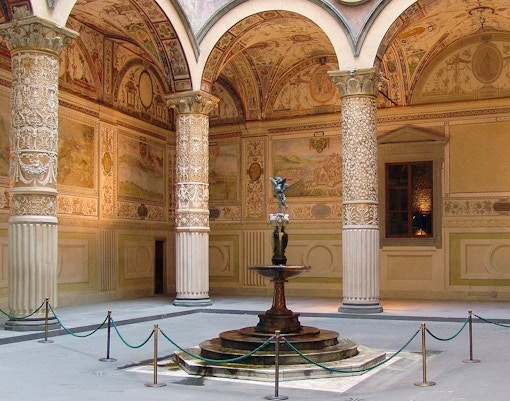 Palazzo Vecchio courtyard with ornate columns and central fountain in Florence, Italy.