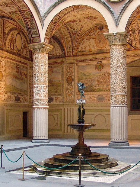 Palazzo Vecchio courtyard with ornate columns and central fountain in Florence, Italy.