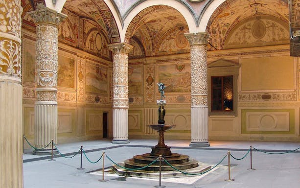 Palazzo Vecchio courtyard with ornate columns and central fountain in Florence, Italy.