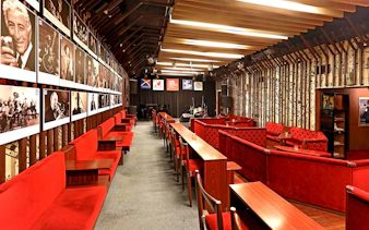 Interior seating and stage at Reduta Jazz Club, Prague, with jazz musician portraits on the wall.