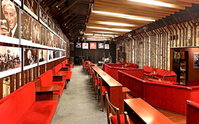 Interior seating and stage at Reduta Jazz Club, Prague, with jazz musician portraits on the wall.
