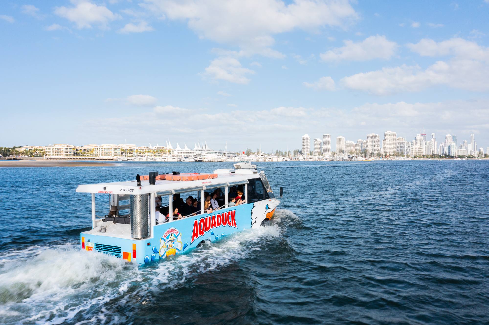 Aquaduck tour vehicle on water with Gold Coast skyline, Australia.