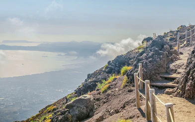 Pathway along Mount Vesuvius with view of Naples coastline in the distance.